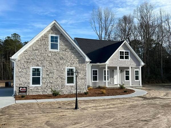 A large stone house with a black roof is for sale