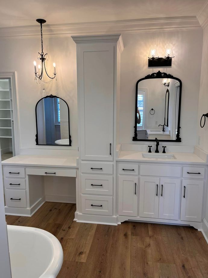 A bathroom with two sinks , two mirrors and a bathtub.