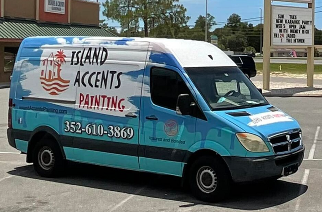 A van that says island accents painting is parked in a parking lot