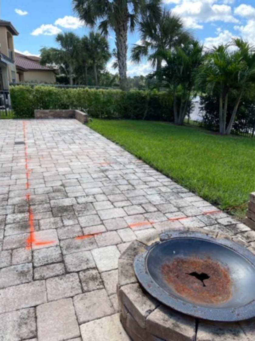 A brick walkway with a fire pit in the middle of it