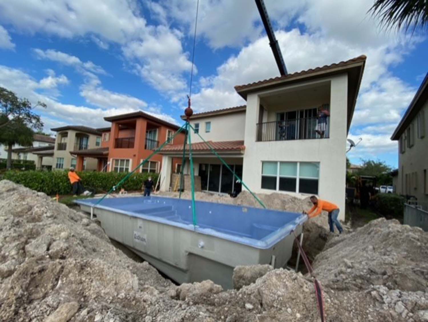 A large swimming pool is being built in front of a house.