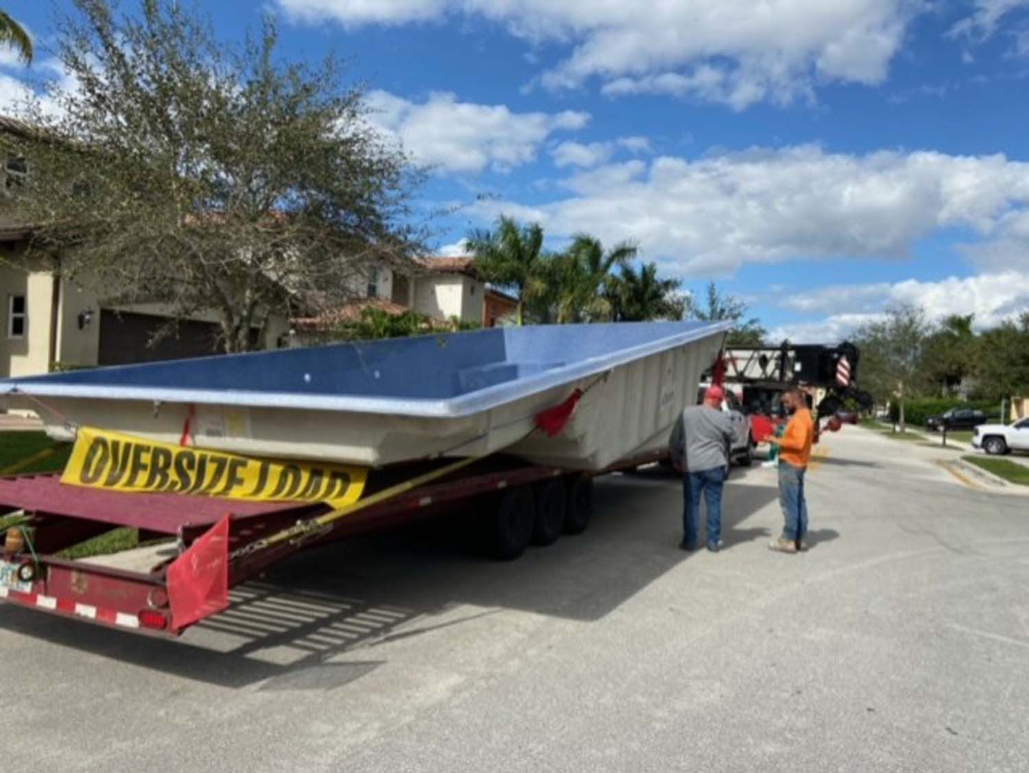 A large swimming pool is being transported on a trailer.