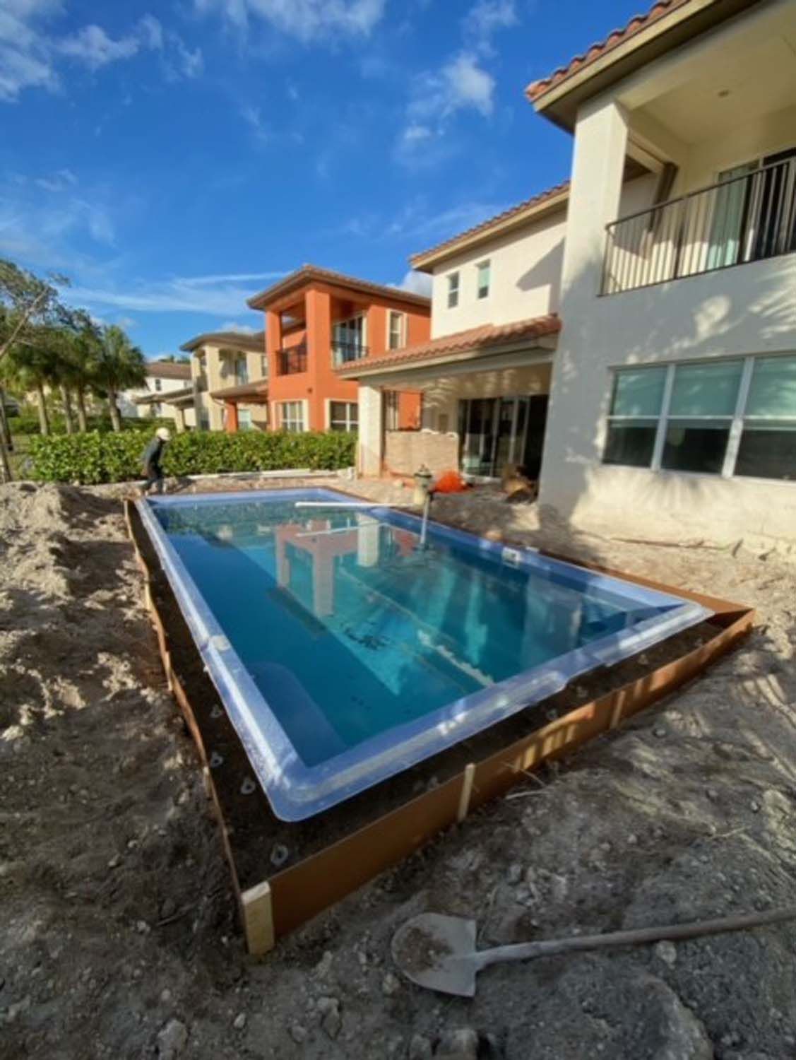 A large swimming pool is being built in front of a house