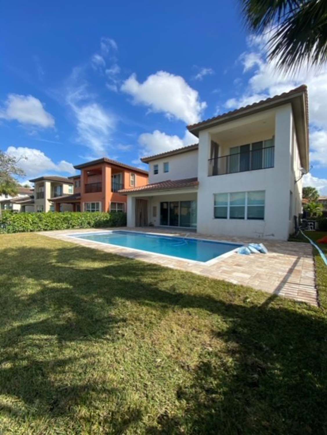 A large house with a large swimming pool in front of it