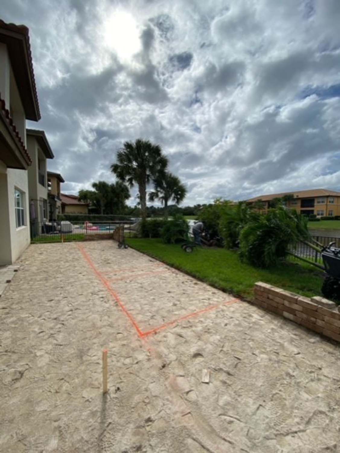 A patio is being built in the backyard of a house.