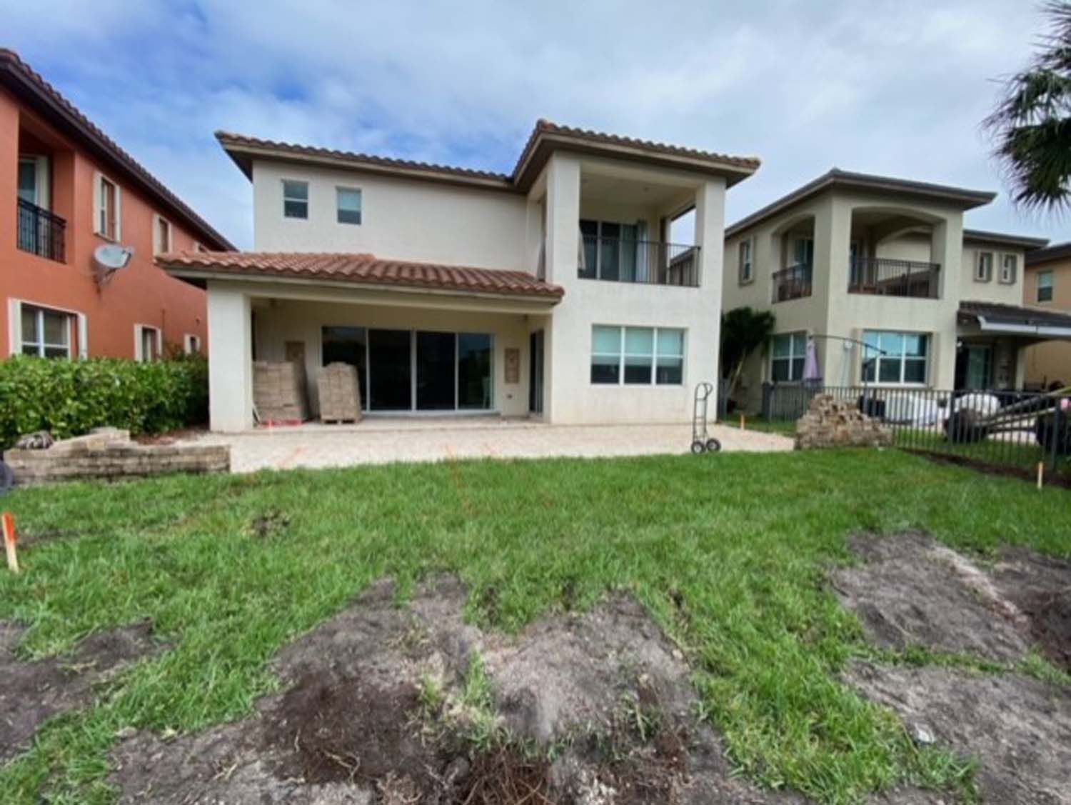 The backyard of a house with a lot of grass and dirt