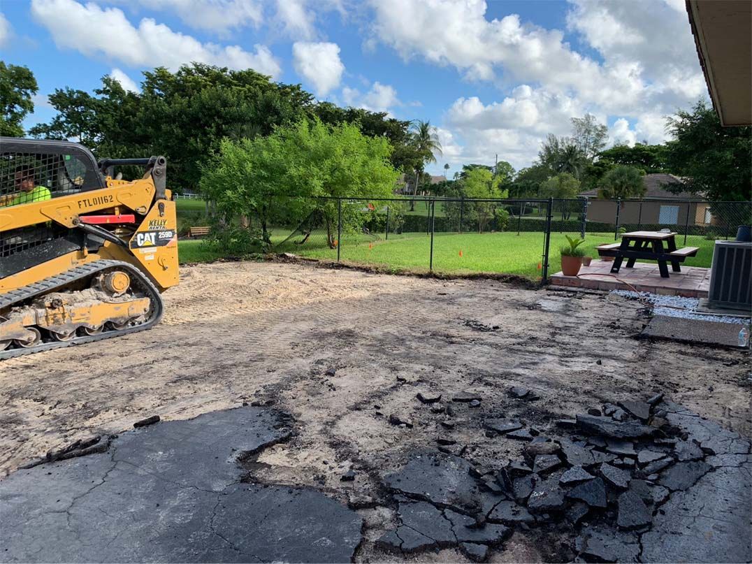 A bulldozer is moving dirt in a backyard.