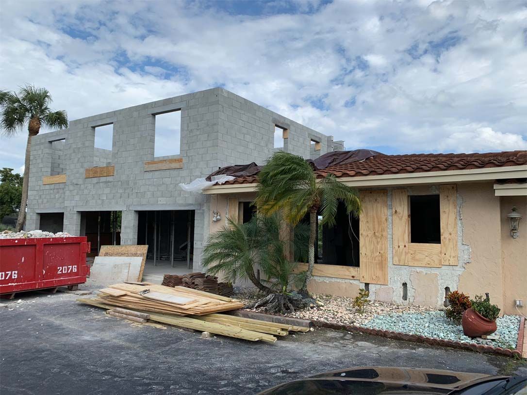 A house under construction with a dumpster in front of it.