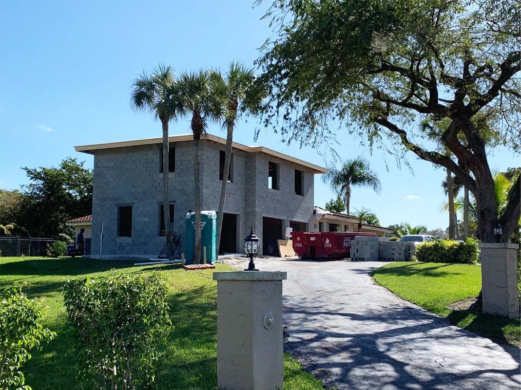 A house is being built in the middle of a lush green field.