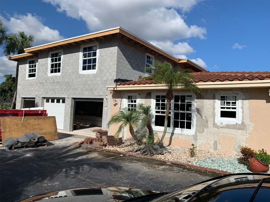 A house under construction with a car parked in front of it.