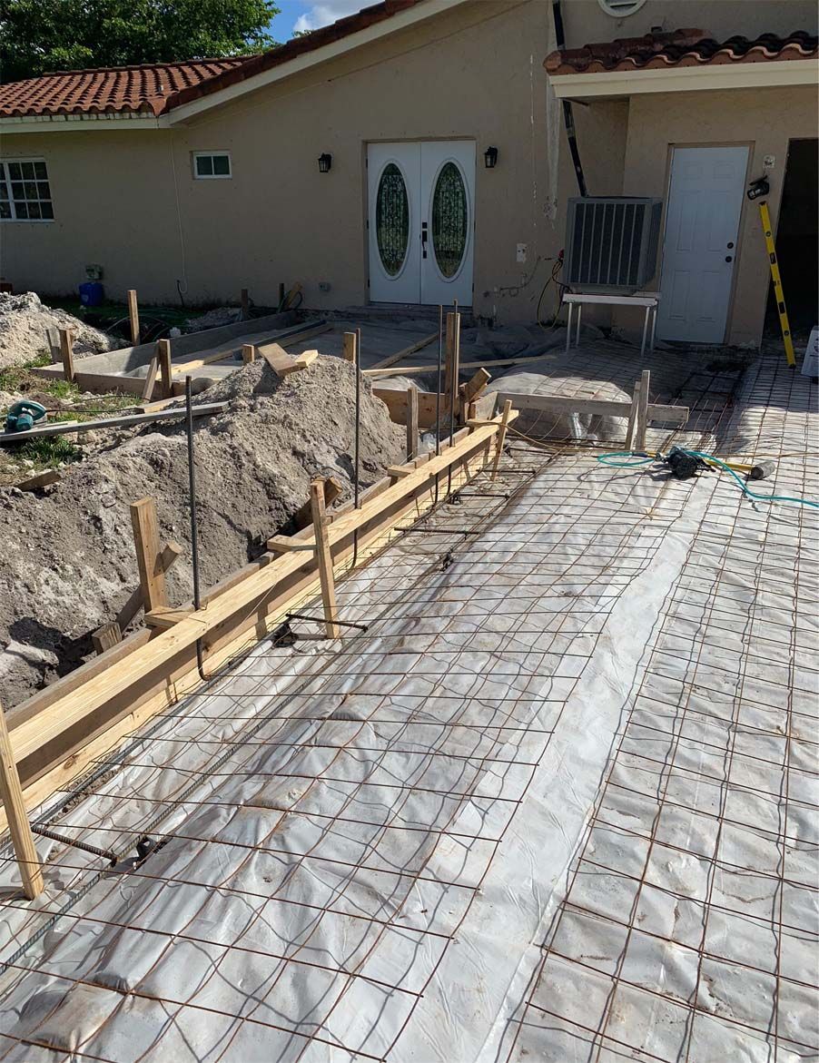 A concrete driveway is being built in front of a house.
