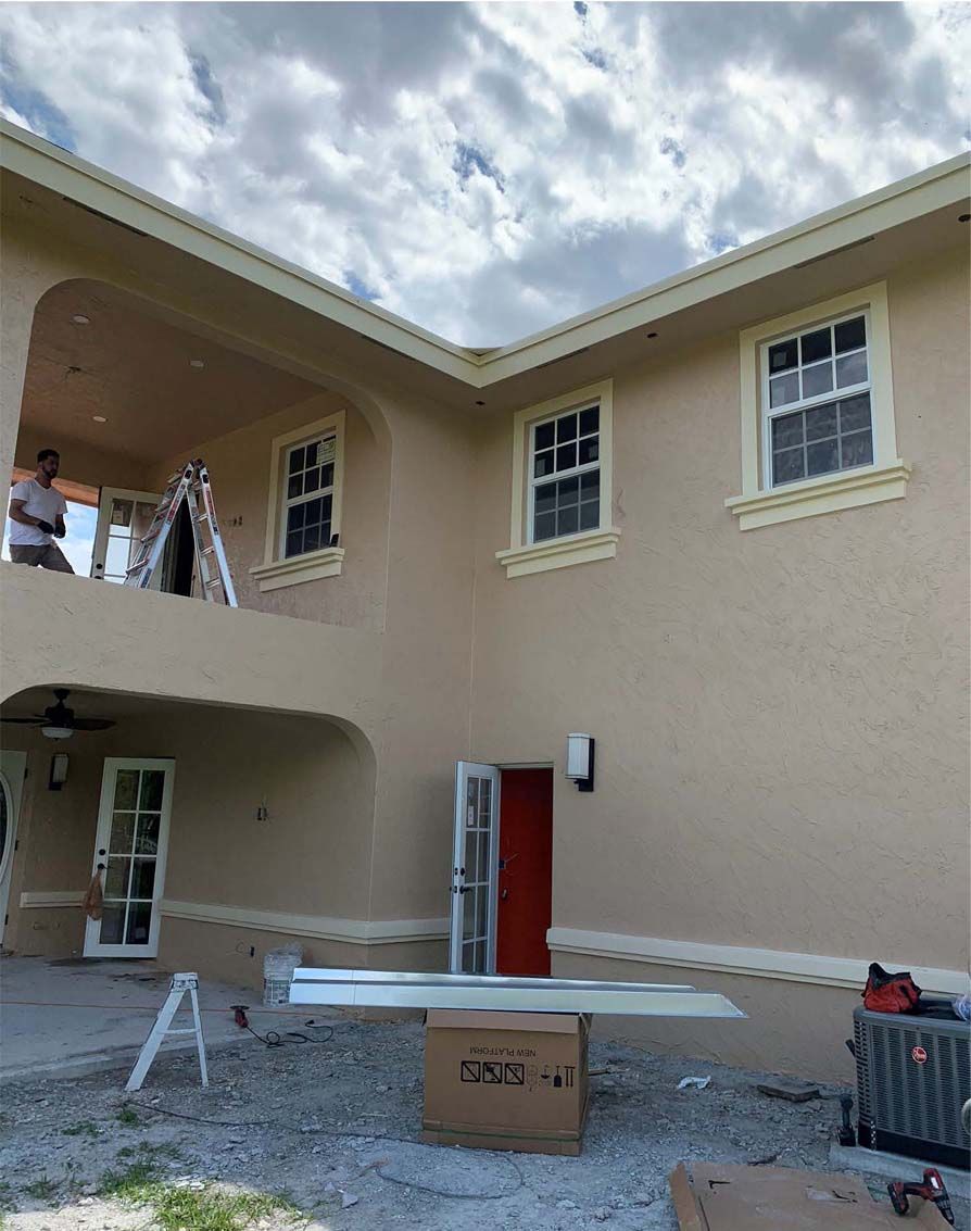 A large house with a ladder and a box in front of it