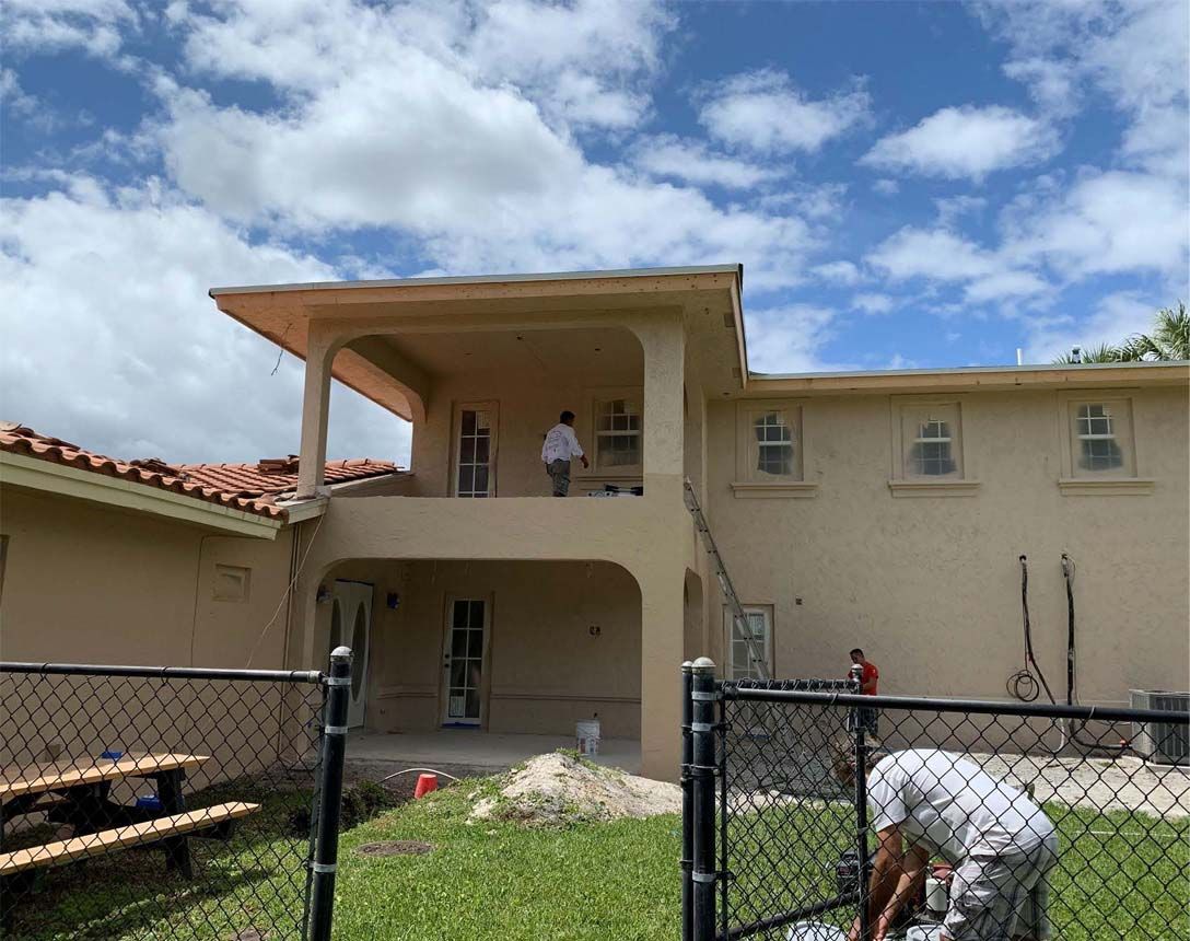 A man is painting the side of a house.