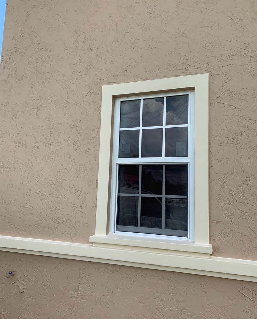A window on the side of a building with a white frame.