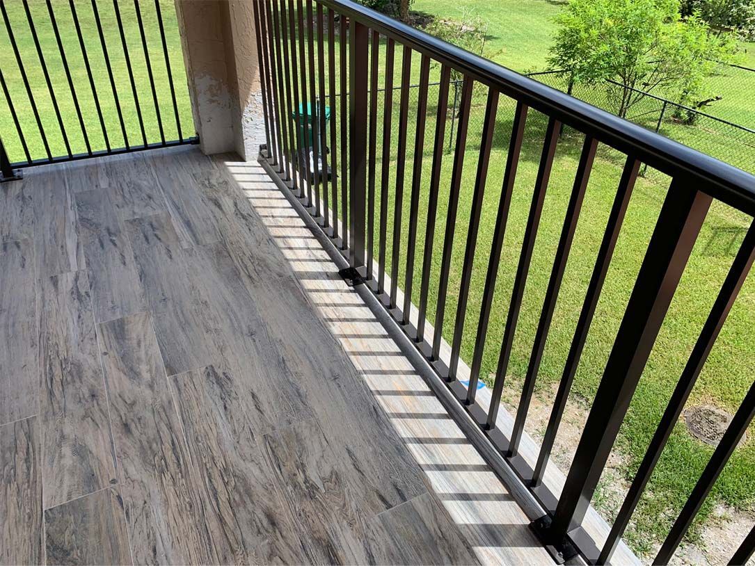 A balcony with a metal railing and a wooden floor.