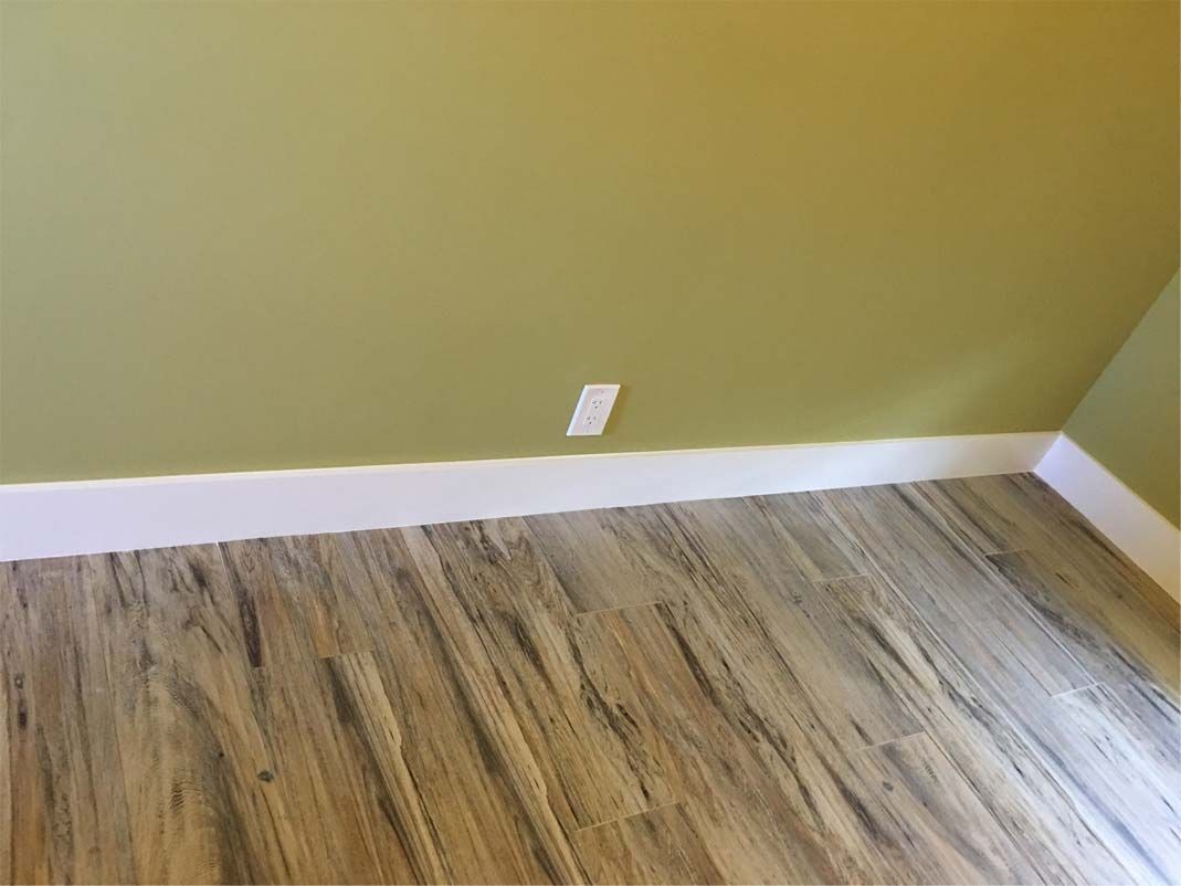 A room with a wooden floor and a green wall.