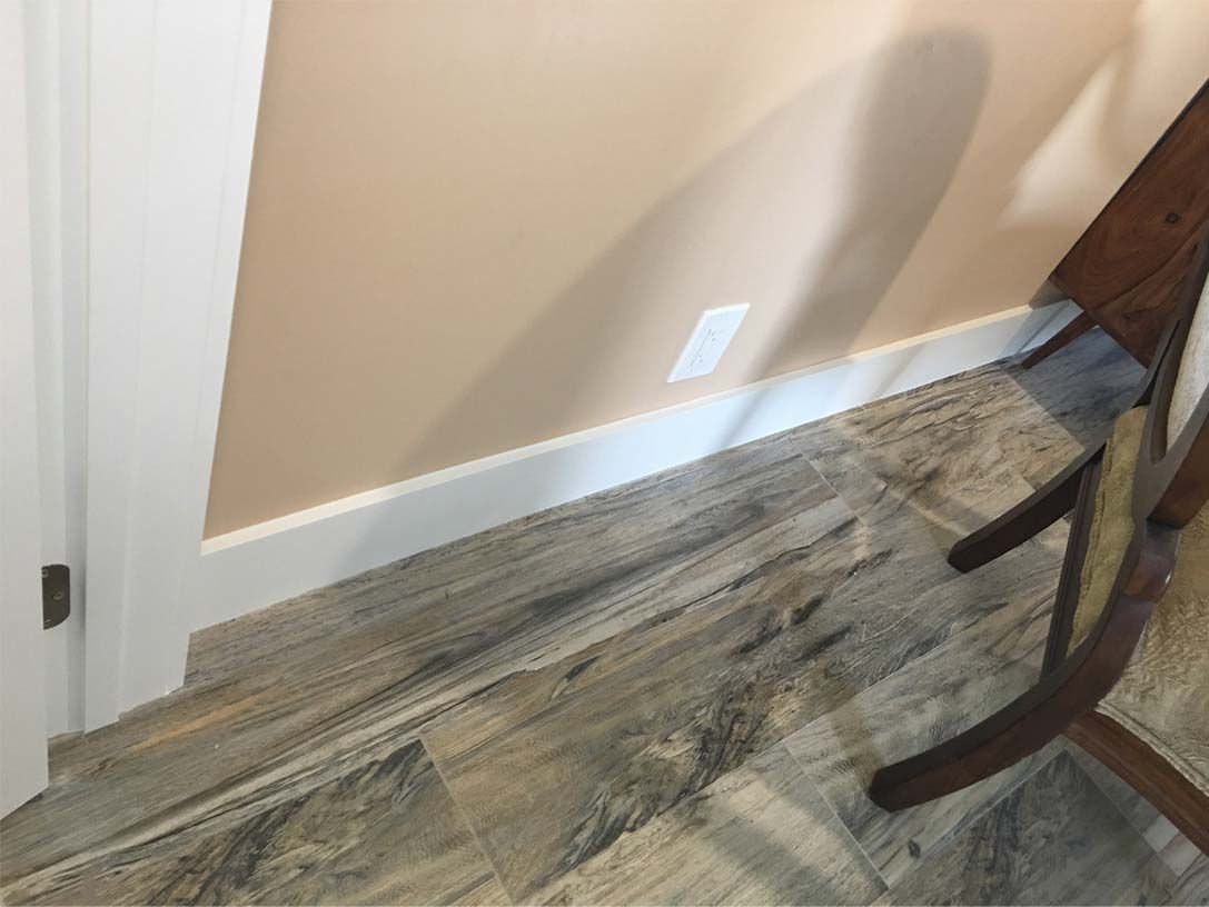 A chair is sitting on a wooden floor next to a door.