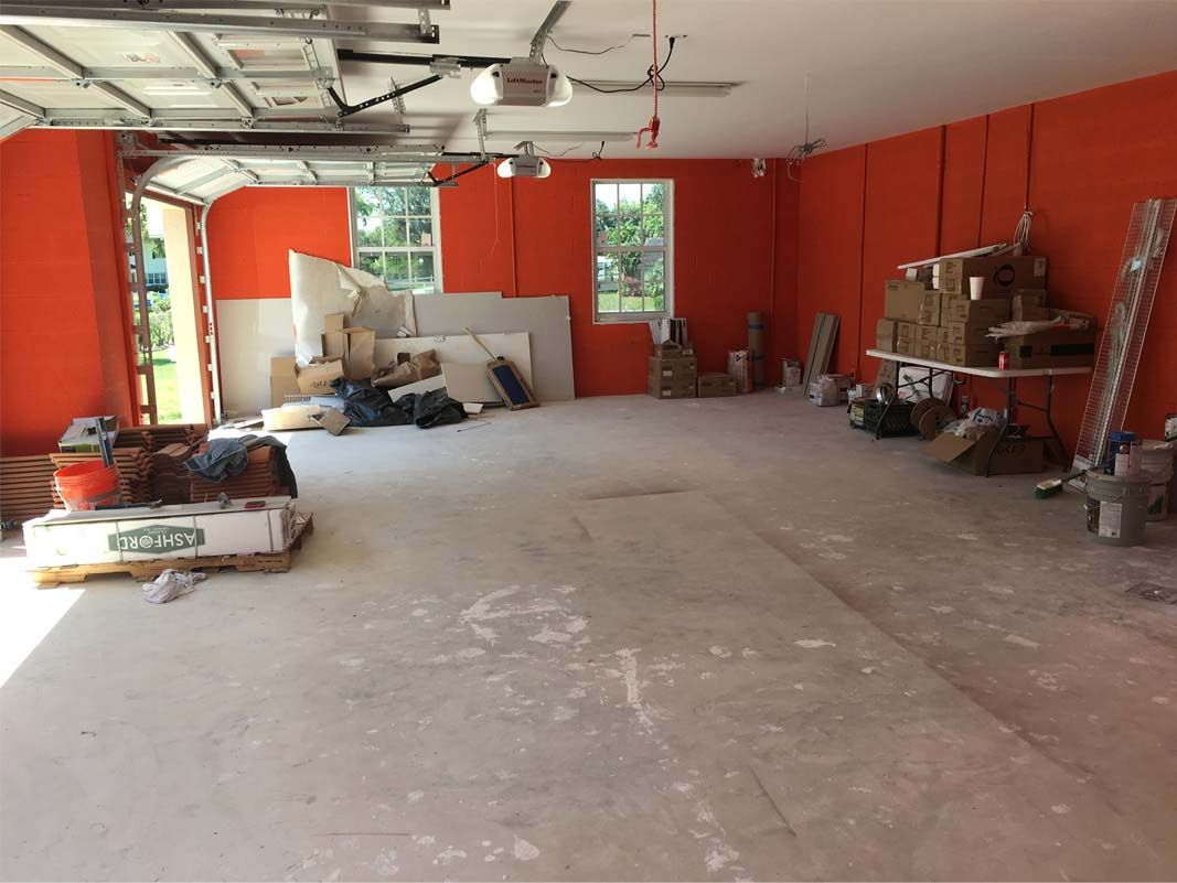 An empty garage with orange walls and a white floor