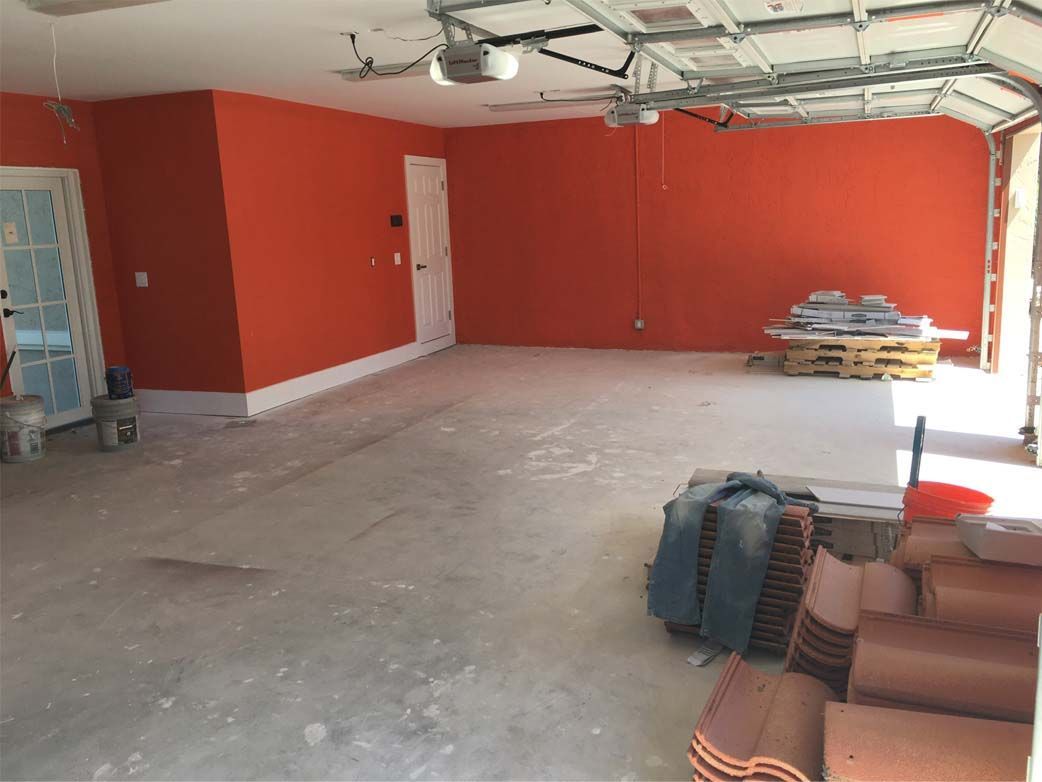 An empty garage with orange walls and tiles on the floor