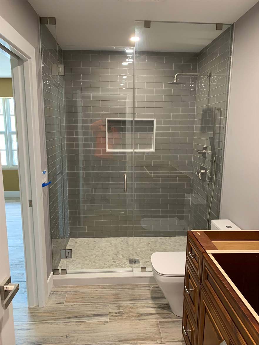 A bathroom with a walk in shower and a toilet.