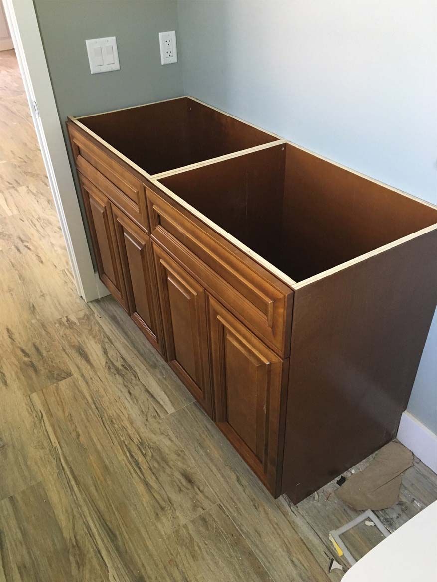 A wooden cabinet with two sinks underneath it in a bathroom.
