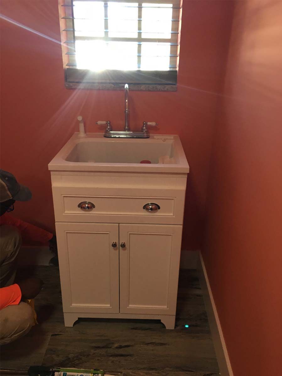 A white sink is sitting in a bathroom next to a window.