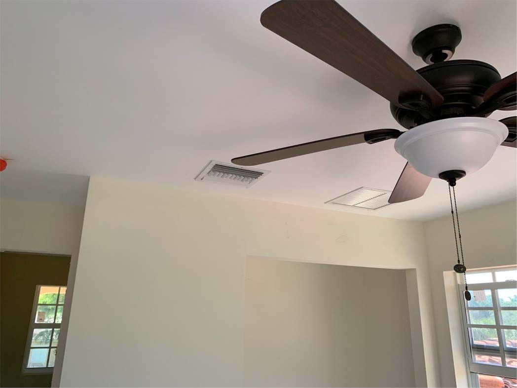 A ceiling fan is hanging from the ceiling of a room