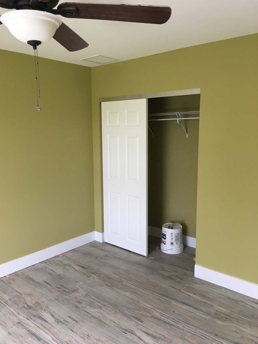 An empty room with a ceiling fan and a closet