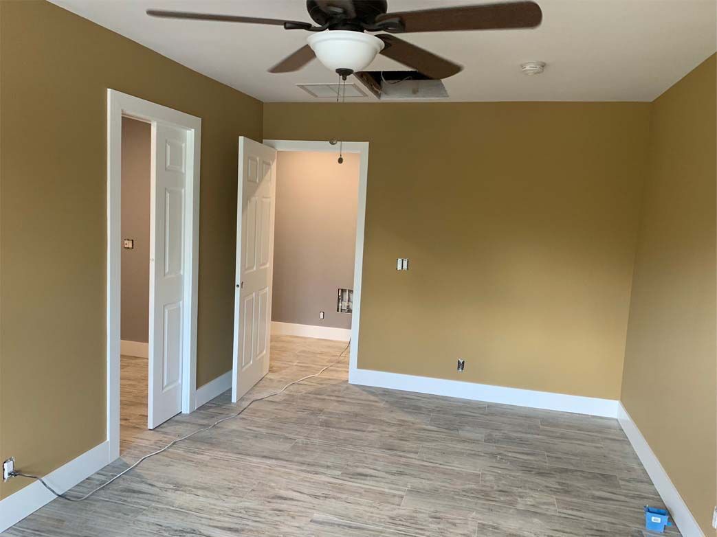 An empty room with a ceiling fan in the corner