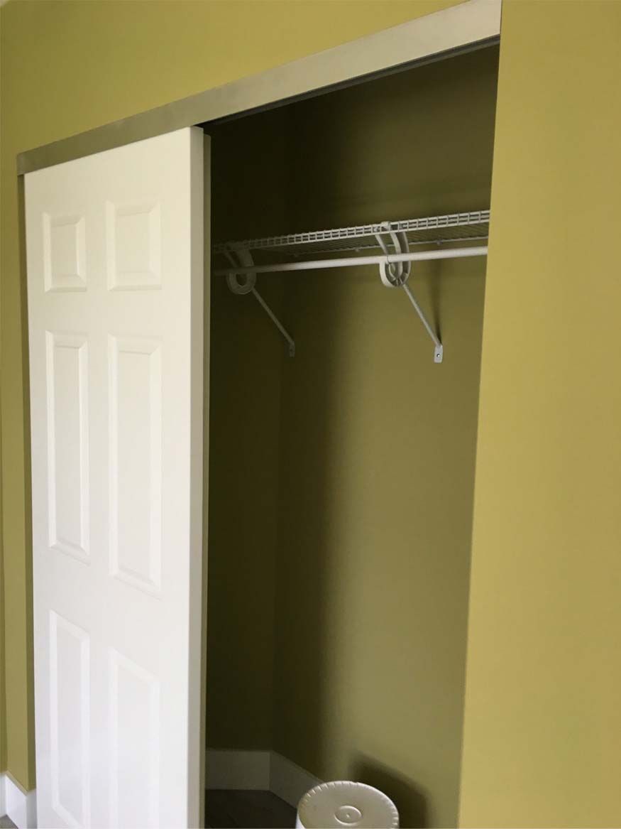 A closet with a sliding door and a shelf.