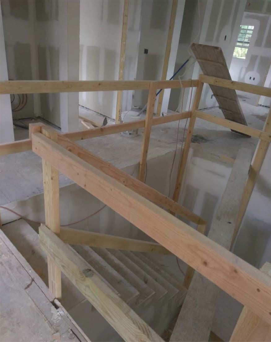 A wooden railing is being built in a building under construction.