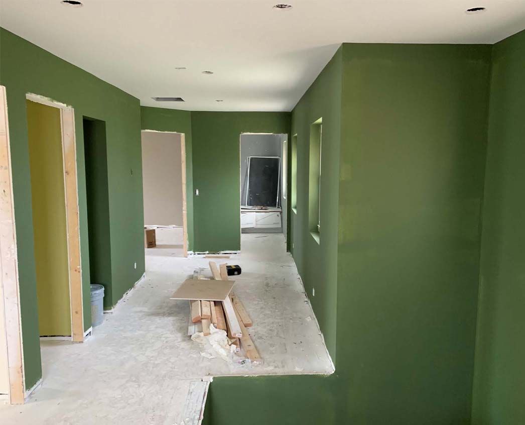 A hallway with green walls and white carpet