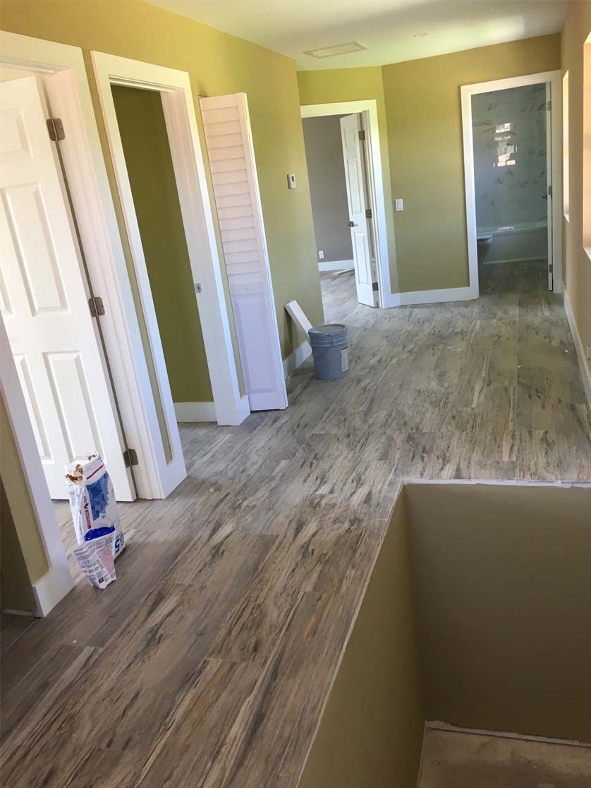 A large room with hardwood floors and lots of doors.