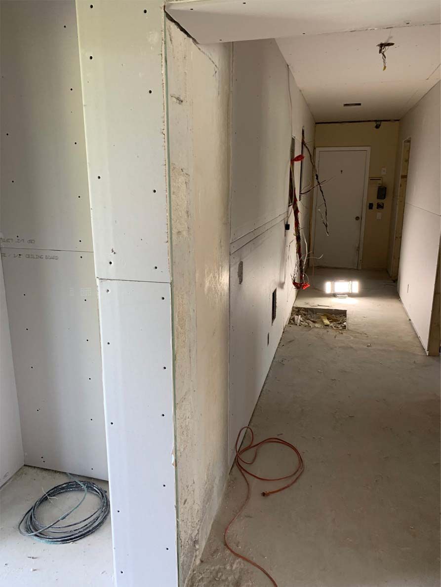 A long hallway with white walls and a red cord hanging from the wall.