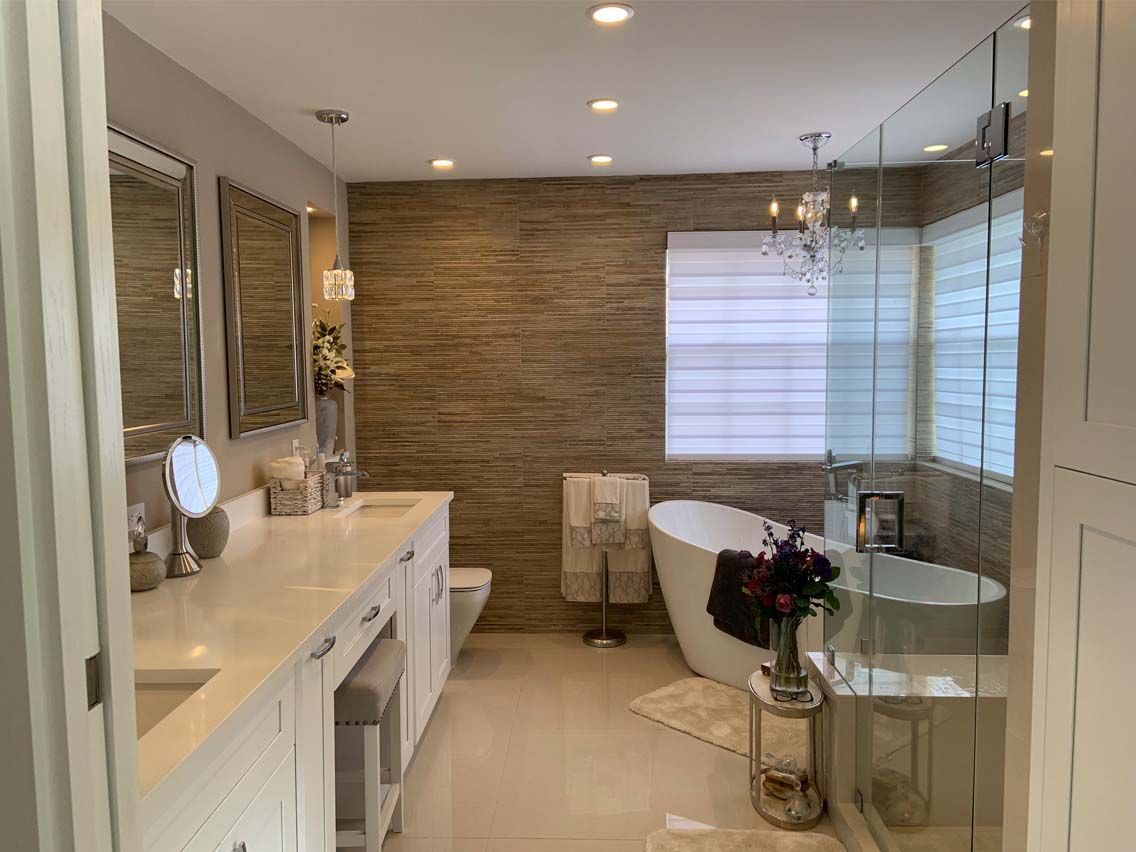 A bathroom with a tub , sink , mirror and walk in shower.