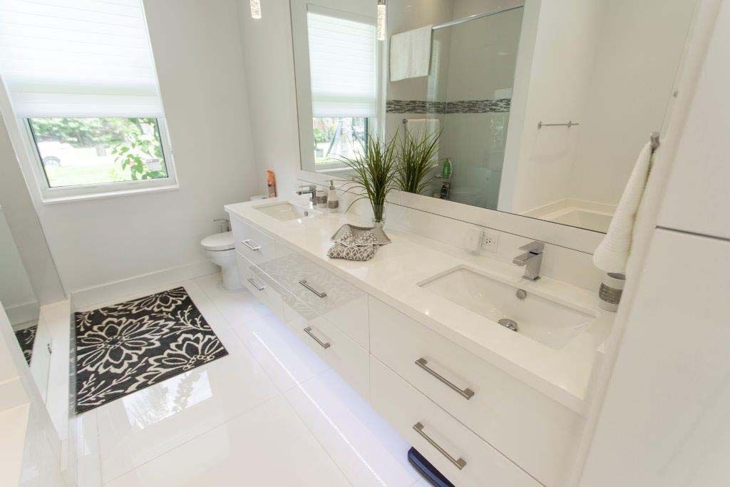 A bathroom with two sinks and a large mirror.