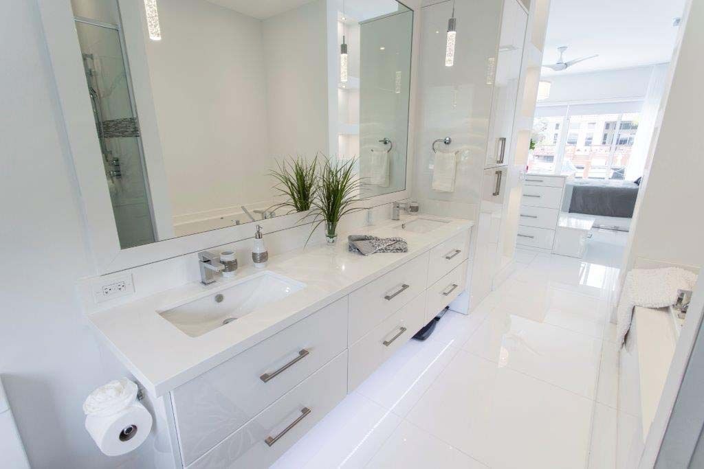 A bathroom with two sinks , a toilet , and a mirror.