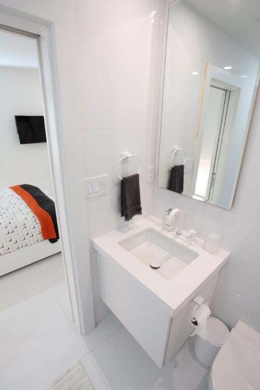 A bathroom with a sink , toilet and mirror.