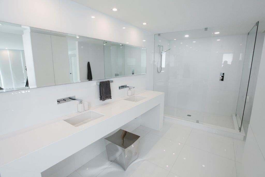 A bathroom with two sinks and a walk in shower.