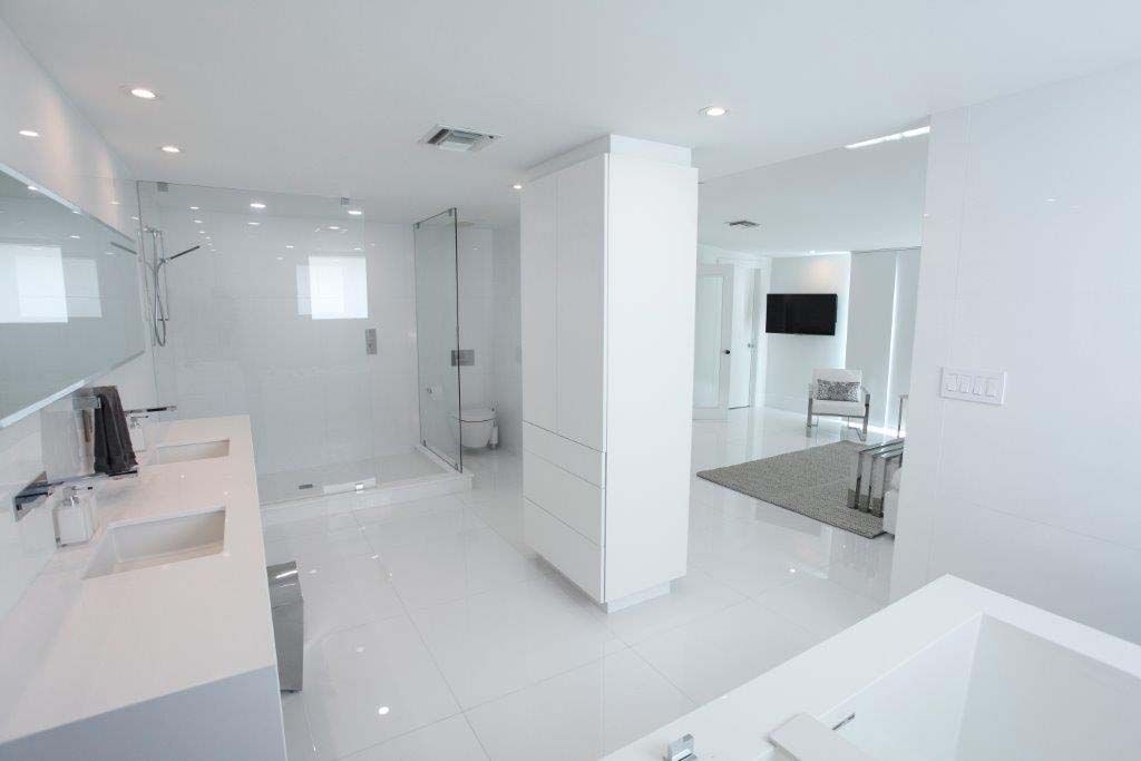 A bathroom with two sinks , a tub , and a walk in shower.