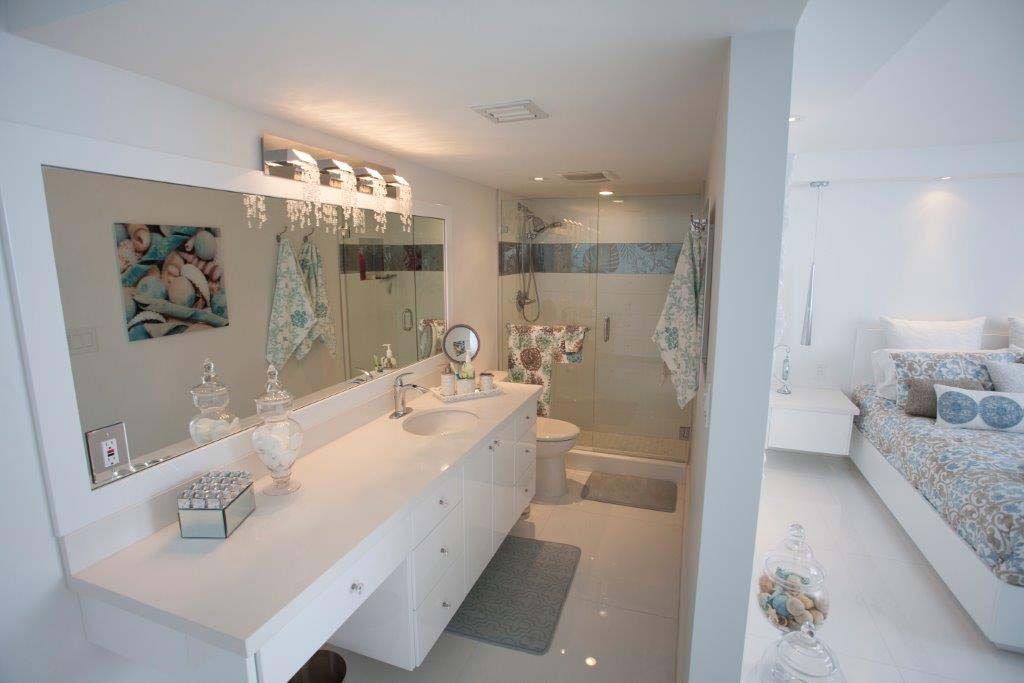 A bathroom with two sinks , a toilet , and a walk in shower.