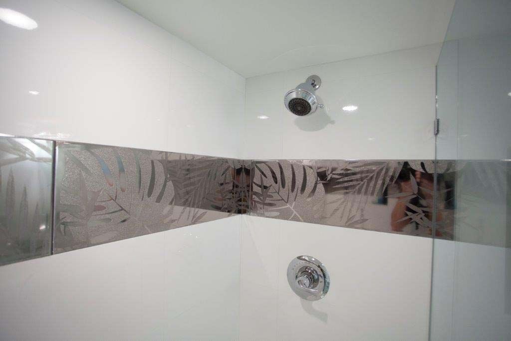 A bathroom with a shower and a mirror.
