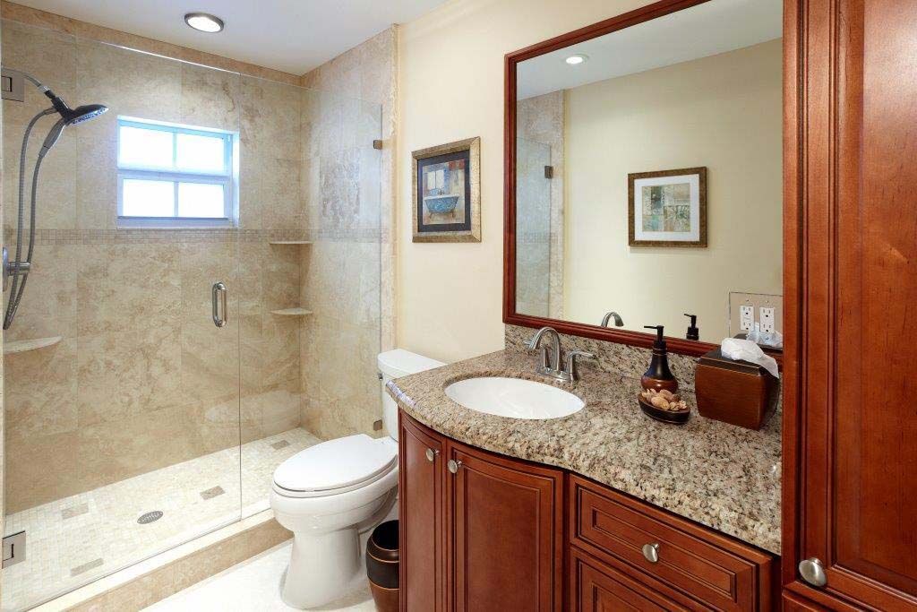 A bathroom with a toilet , sink , and shower.