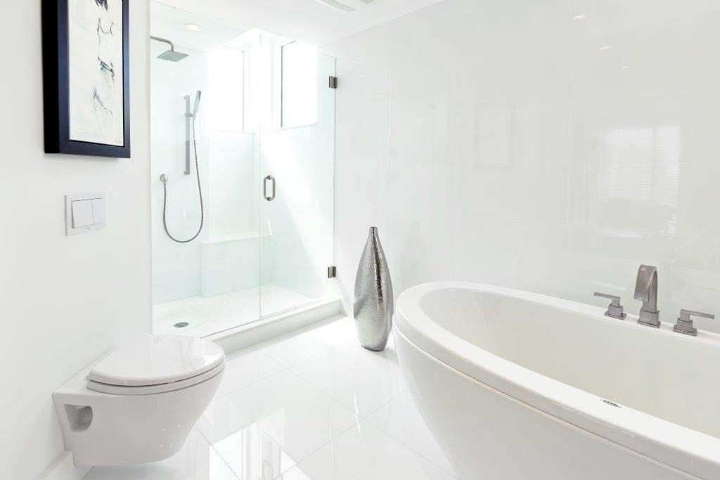 A bathroom with a bathtub , toilet and shower.