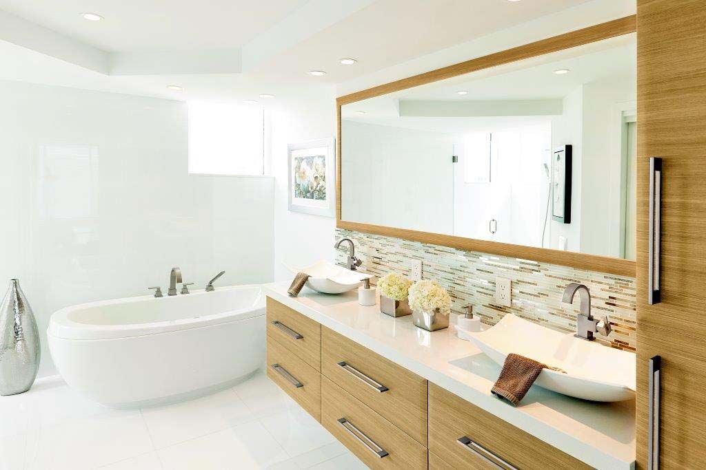 A bathroom with two sinks , a bathtub and a large mirror.