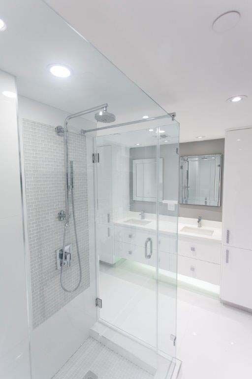 A bathroom with a walk in shower and a sink.