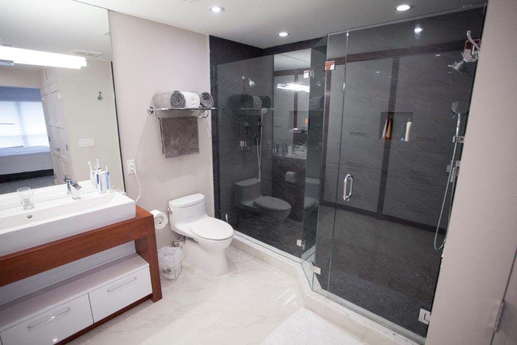 A bathroom with a toilet , sink and shower.