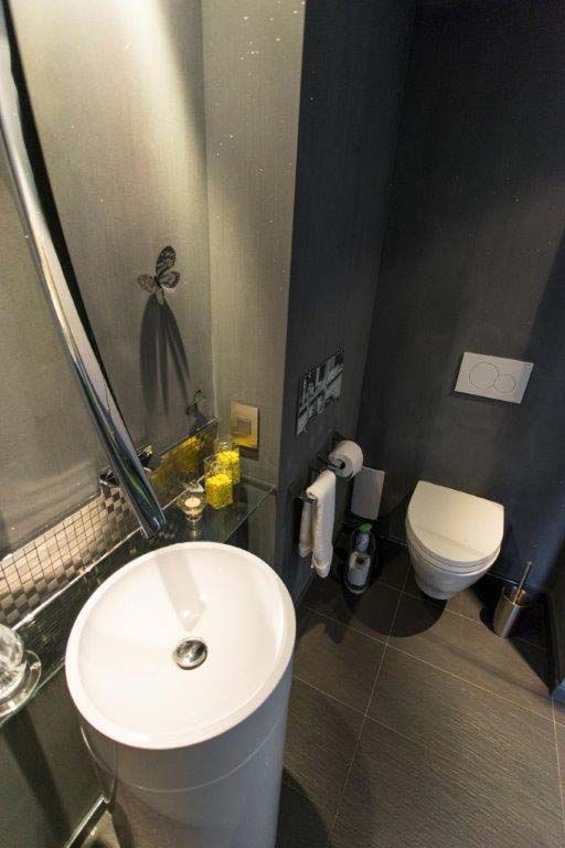 A bathroom with a sink , toilet and mirror.