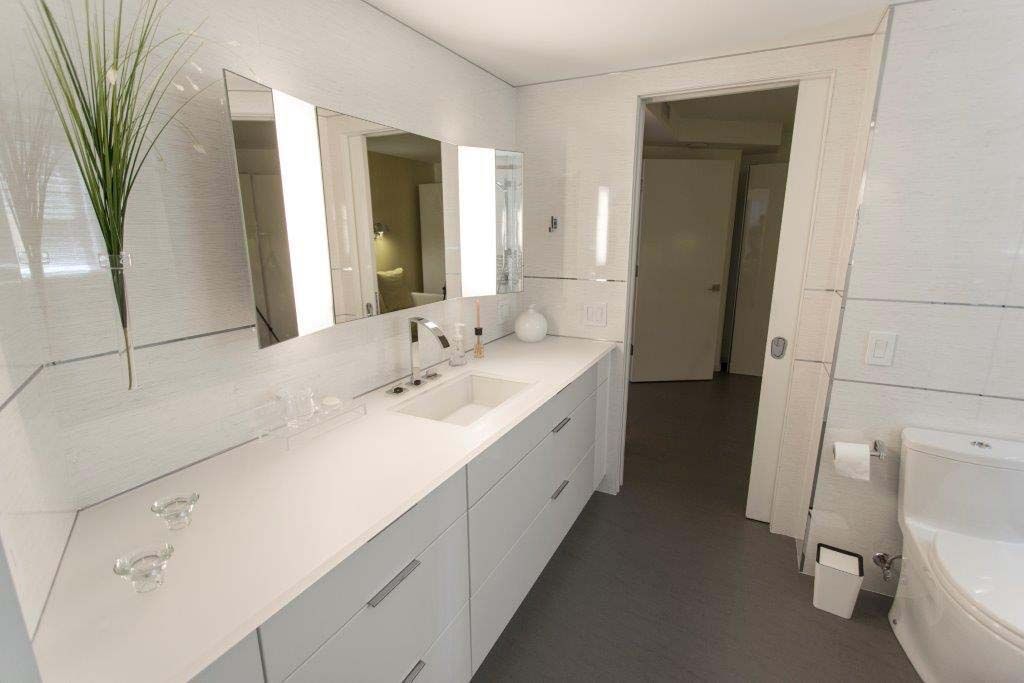 A bathroom with two sinks , two mirrors and a tub.