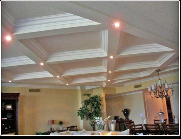 A living room with a coffered ceiling and a chandelier